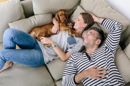 Happy couple on couch with dog