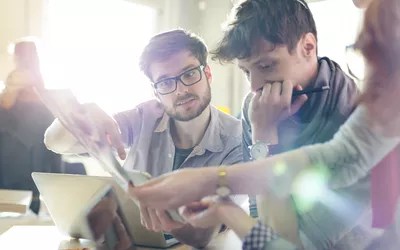 Creative business people reviewing proofs in sunny office