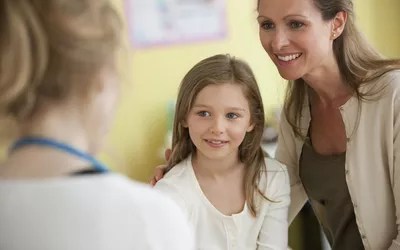 Mother and daughter with doctor in doctor's office